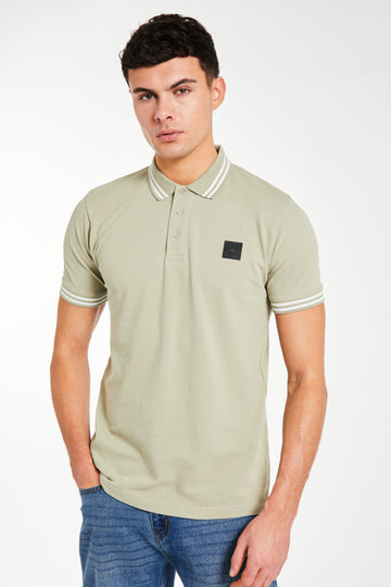 model wearing 'Relate' sage green polos for men 