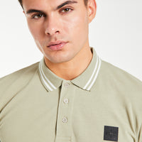 Close up of men's polo shirts sale in green with ''Avant Garde Paris' logo