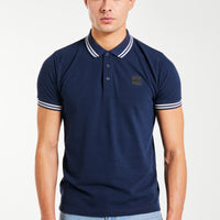 Model wearing men's polo shirts sale in navy blue with white trim 
