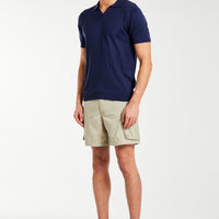 Knitted polo in dark blue styled with shorts