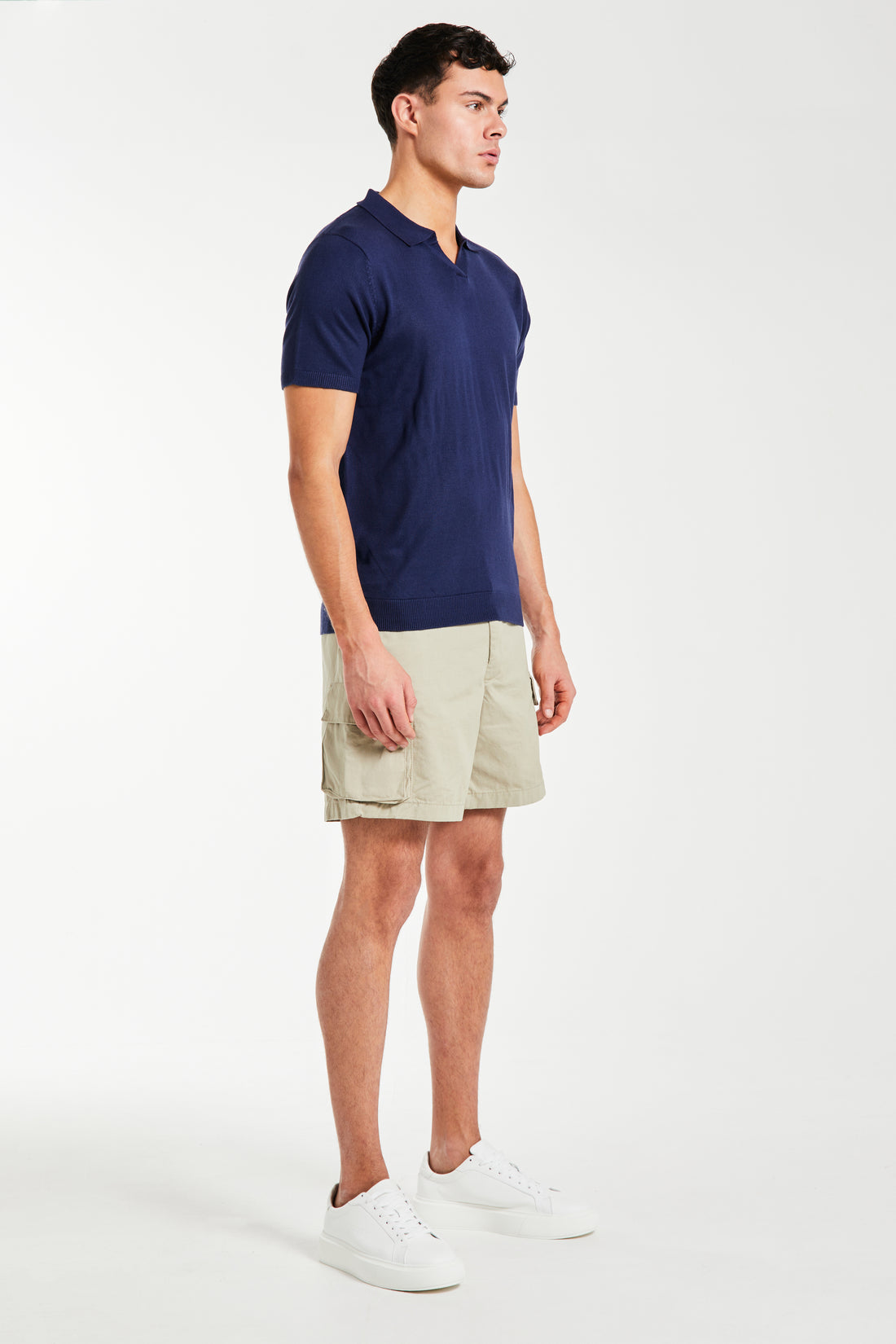 Side profile of a men's knitted polo in navy with shorts