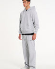 Model facing to the left wearing full grey tracksuit