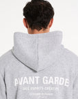 Close up backshot of model wearing grey hoodie with Avant Garde logo on the back