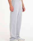Model facing to the right wearing grey tracksuit bottoms