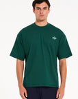 Front shot of model wearing green crew neck T-shirt with Avant Garde logo