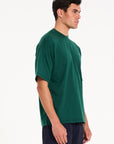 Model facing off to the right wearing green crew neck T-shirt