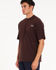 Model facing to the left wearing brown crew neck T-shirt