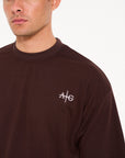 Close up shot of brown crew neck T-shirt with Avant Garde logo