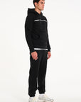 Model facing sidewards wearing men's full tracksuit