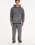 Model facing forward wearing matching hoodie and tracksuit bottoms in steel colour