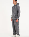 Model facing to the left wearing matching hoodie and tracksuit bottoms in steel