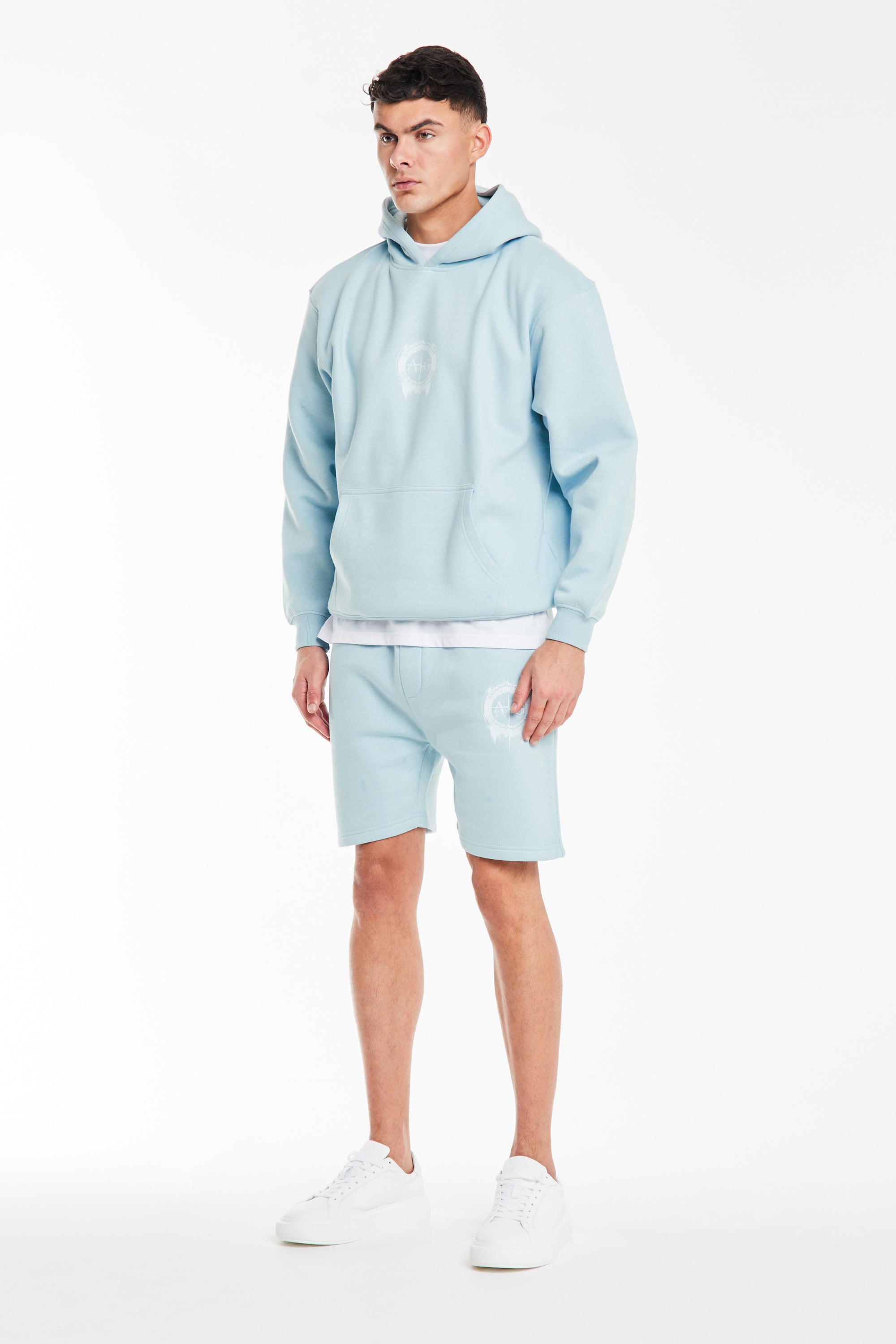 model wearing mens twin short sets in sky blue with logo on chest
