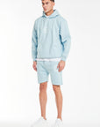 model wearing mens twin short sets in sky blue with logo on chest