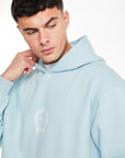 Close up of mens coord set hoodie in baby blue with logo on chest