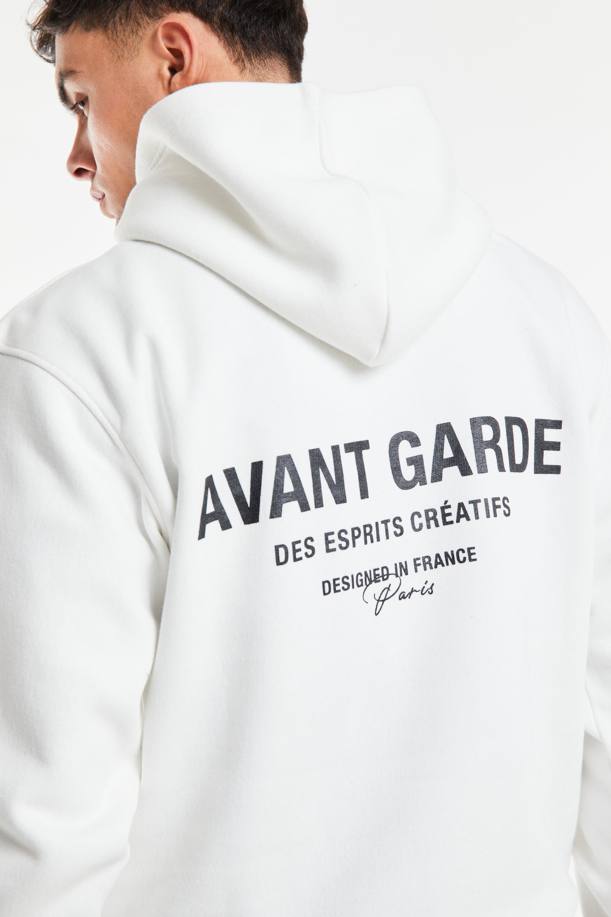 close up of the back of men's hoodies in ecru with 'Avant Garde' logo on back