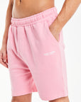 model wearing jersey shorts in pink with white logo