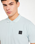 close up of 'Avant Garde Paris' logo on cheap polo shirt in baby blue