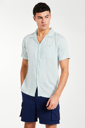 Model wearing a sky blue summer shirt paired with shorts
