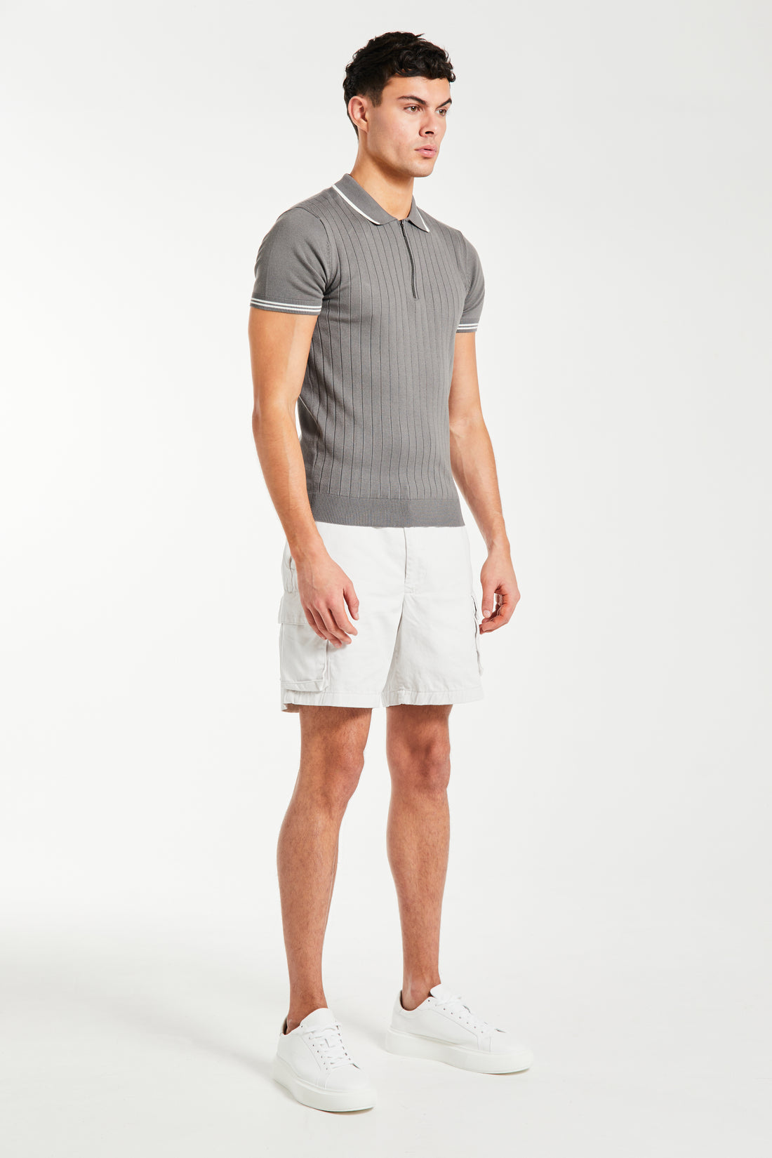 model wearing white men's utility shorts with a polo