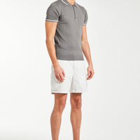 model wearing white men's utility shorts with a polo