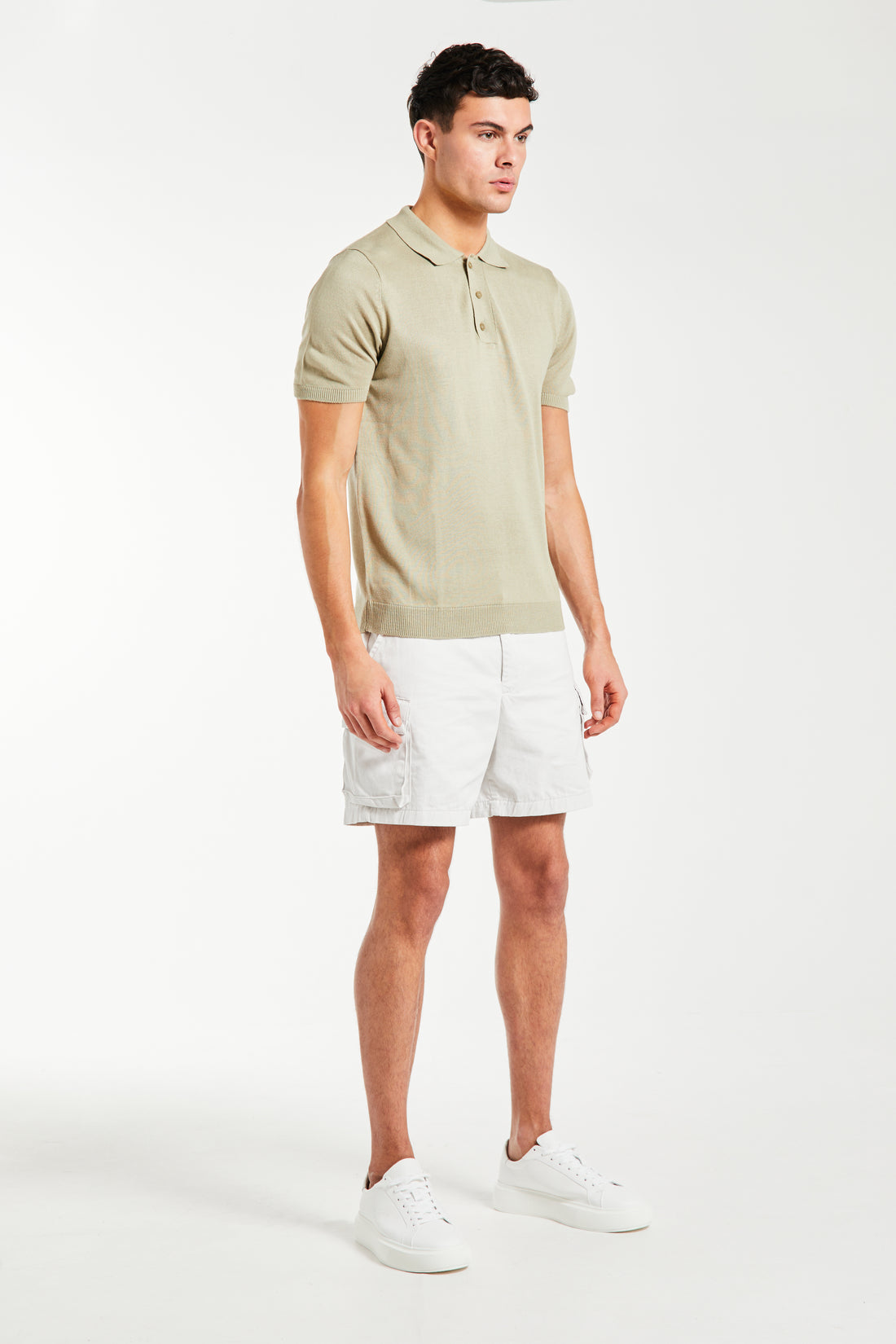 Oatmeal knitted polo on male model styled with shorts