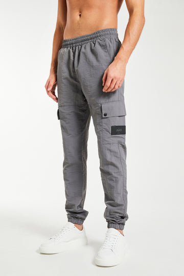 model wearing dark grey cuffed cargo pants sale with badge on the leg