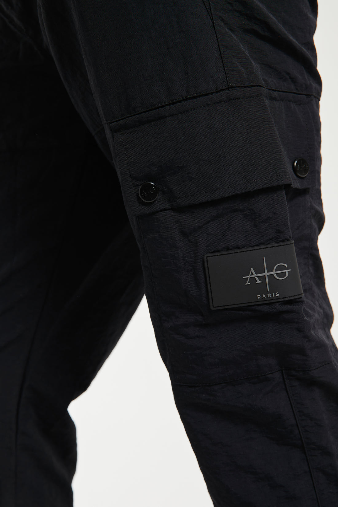 close up of 'Avant Garde Paris' badge on the side of cargo pants in black