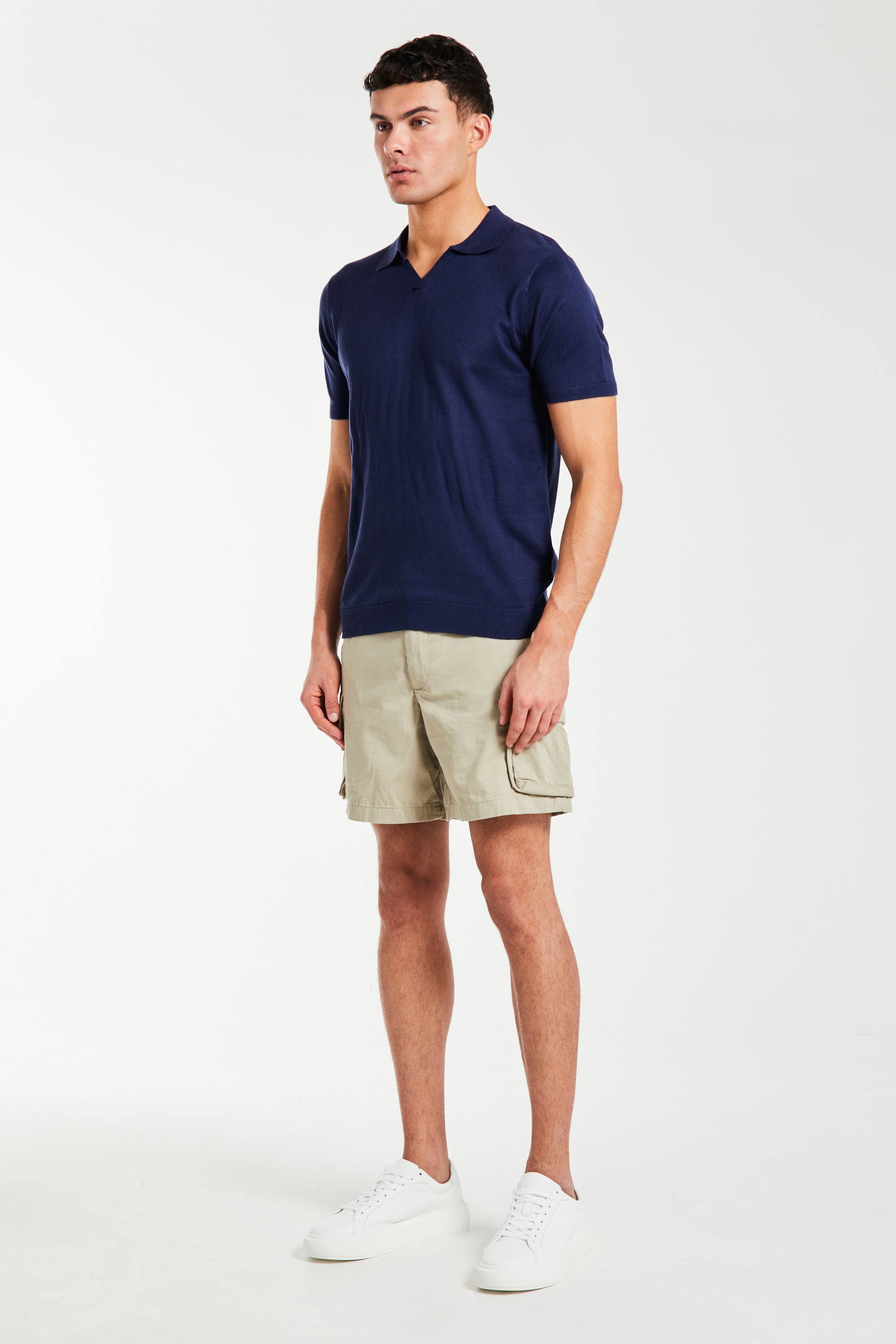 model wearing beige men's utility shorts with polo