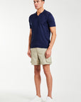 model wearing beige men's utility shorts with polo