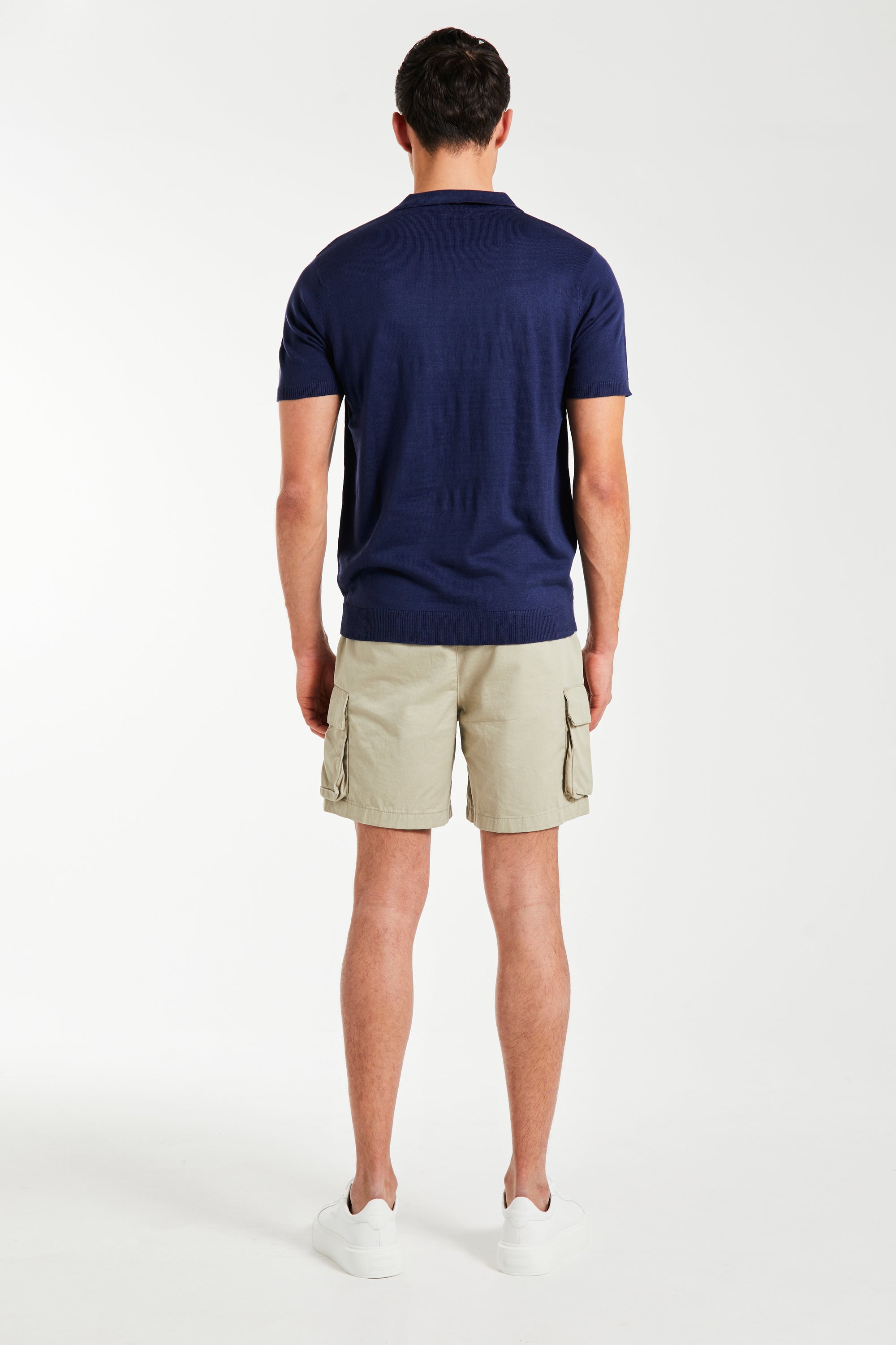 back profile of model wearing men&#39;s utility shorts and polo