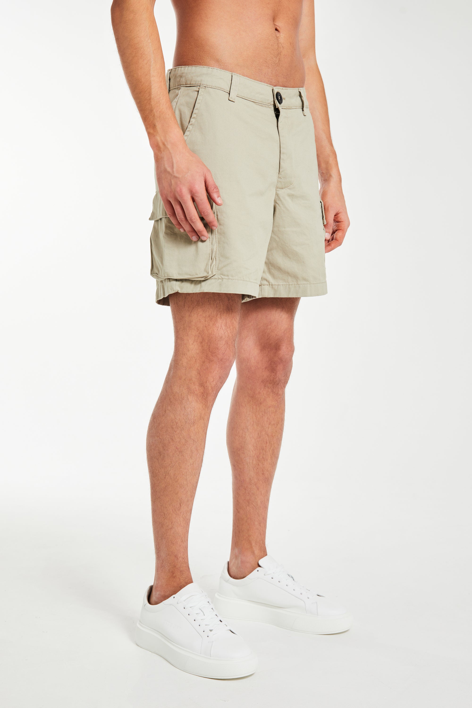 model wearing men's utility shorts in beige with white trainers