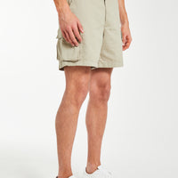 model wearing men's utility shorts in beige with white trainers