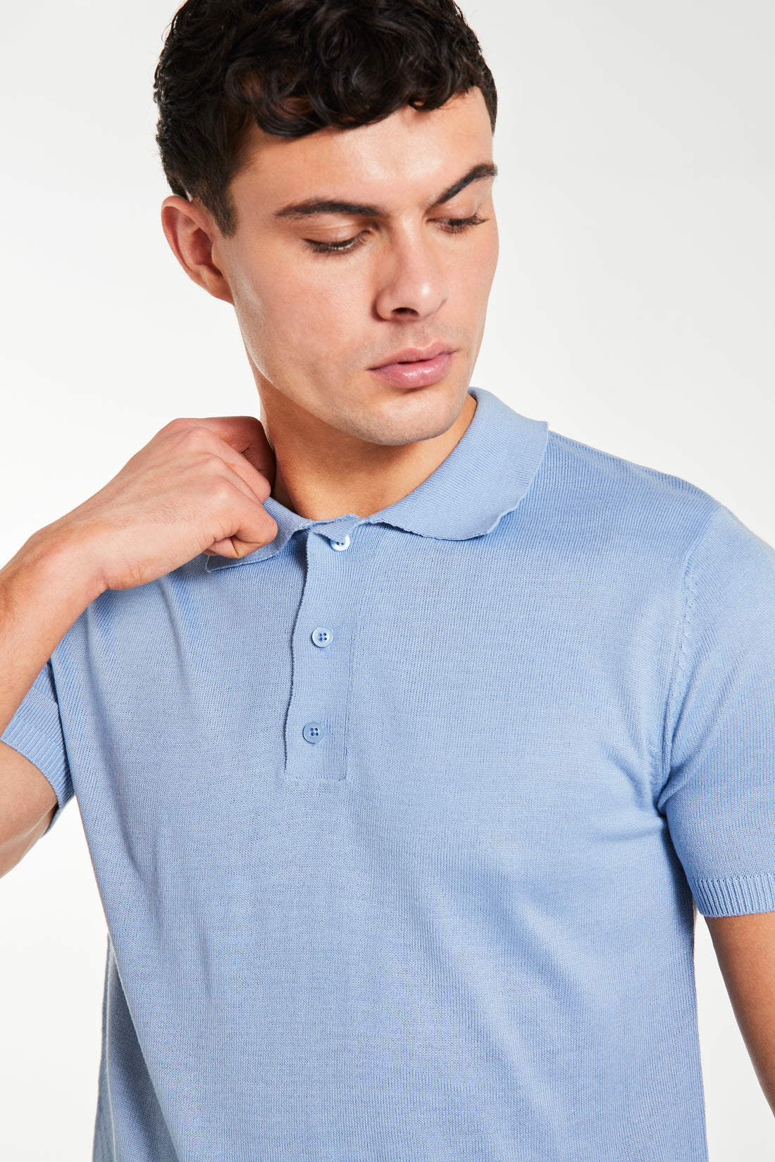 close up of a button up sky blue knitted polo