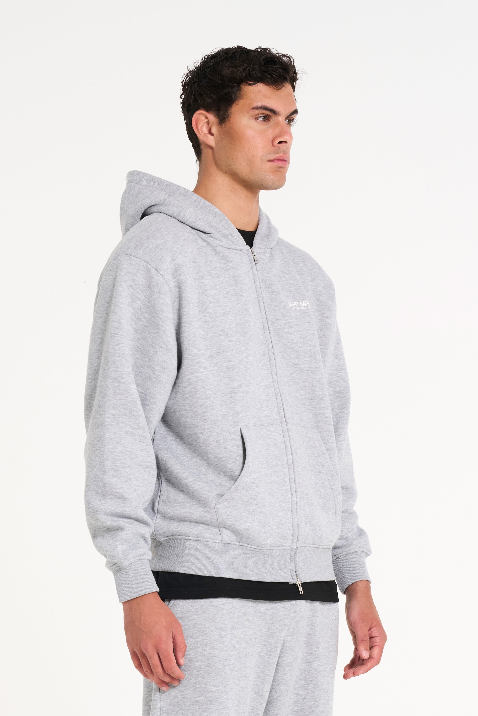 Model wearing grey zip up hoodie facing to the right