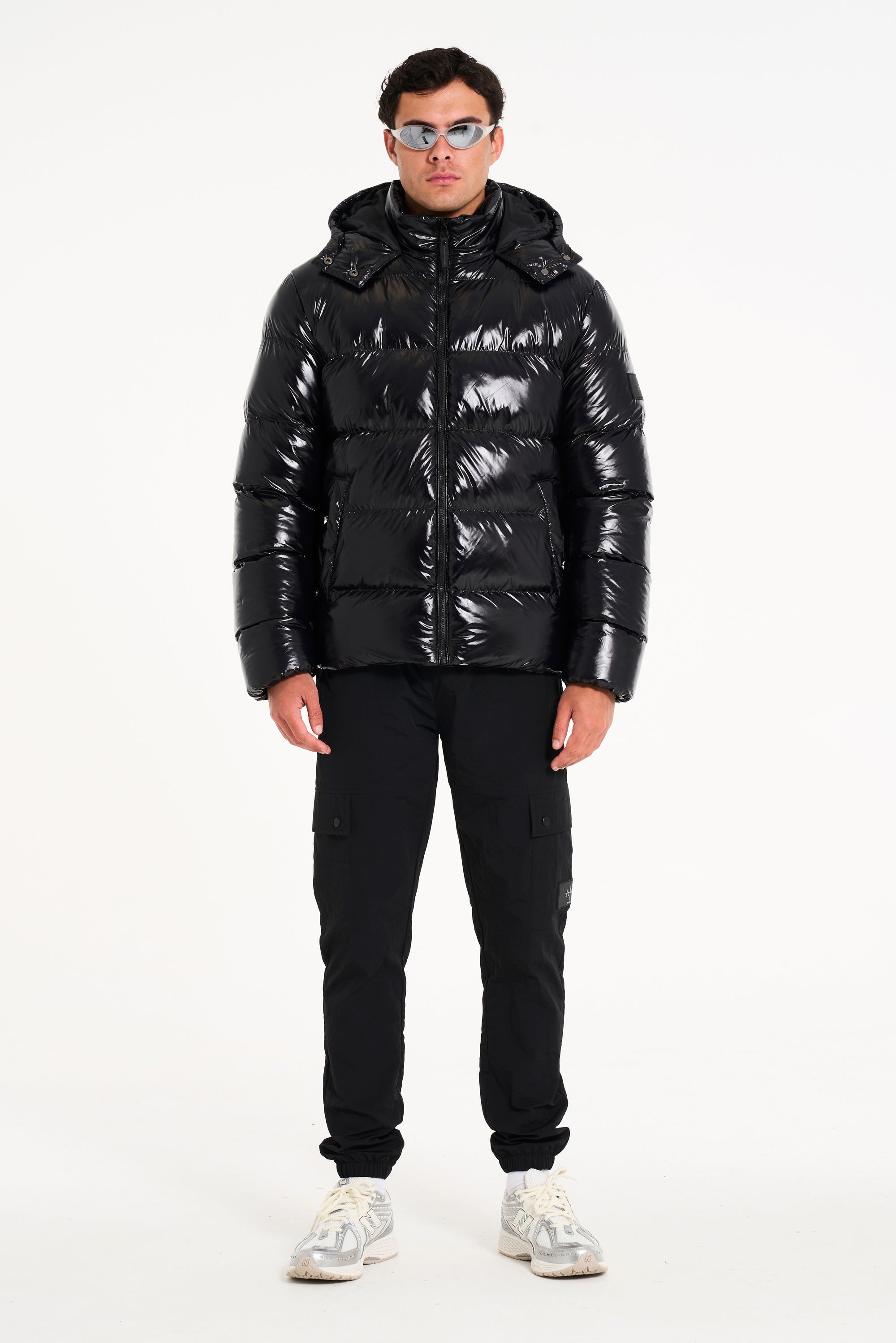 Model wearing hooded puffer jacket and black cargo pants