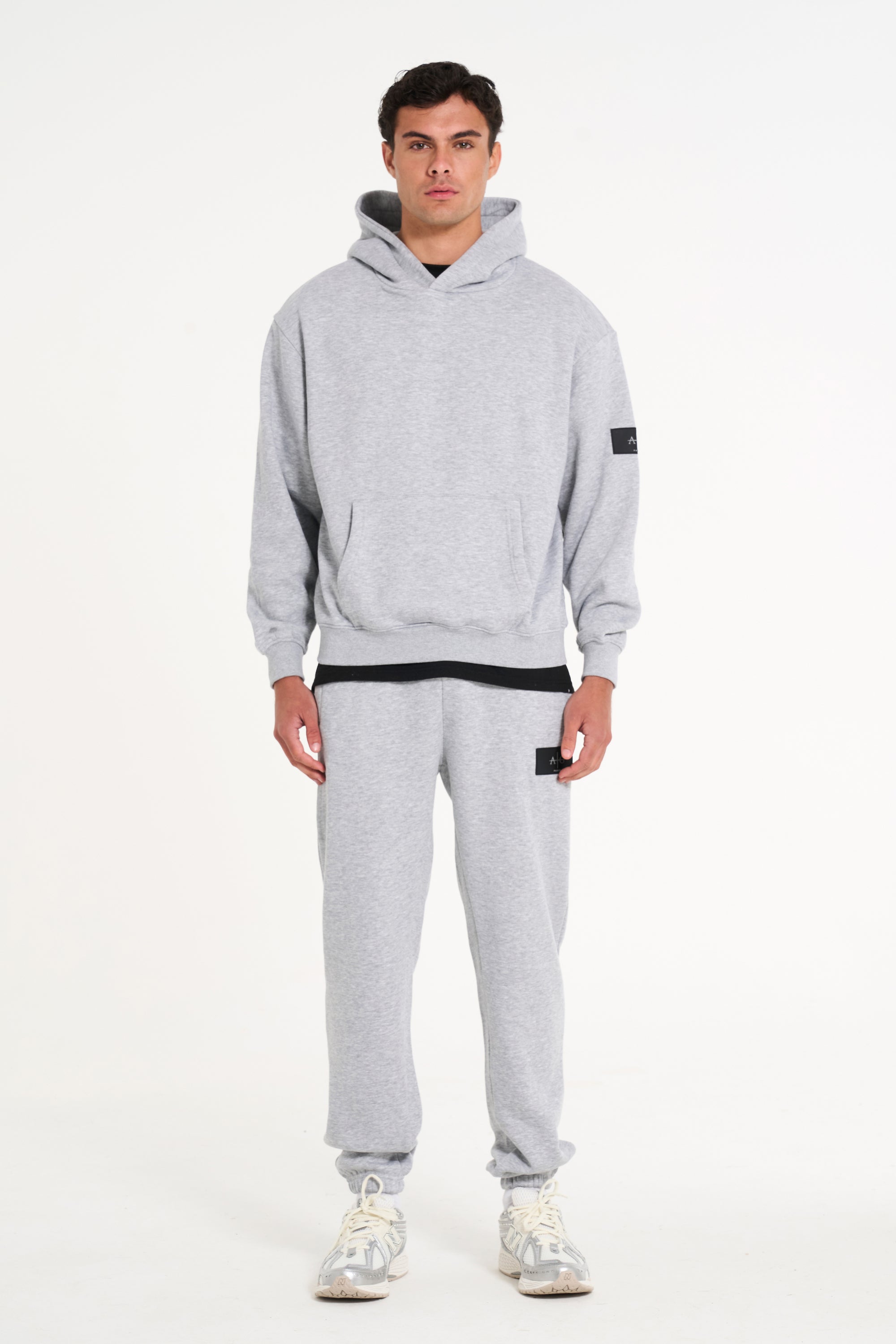 Model facing forward wearing full grey badge tracksuit