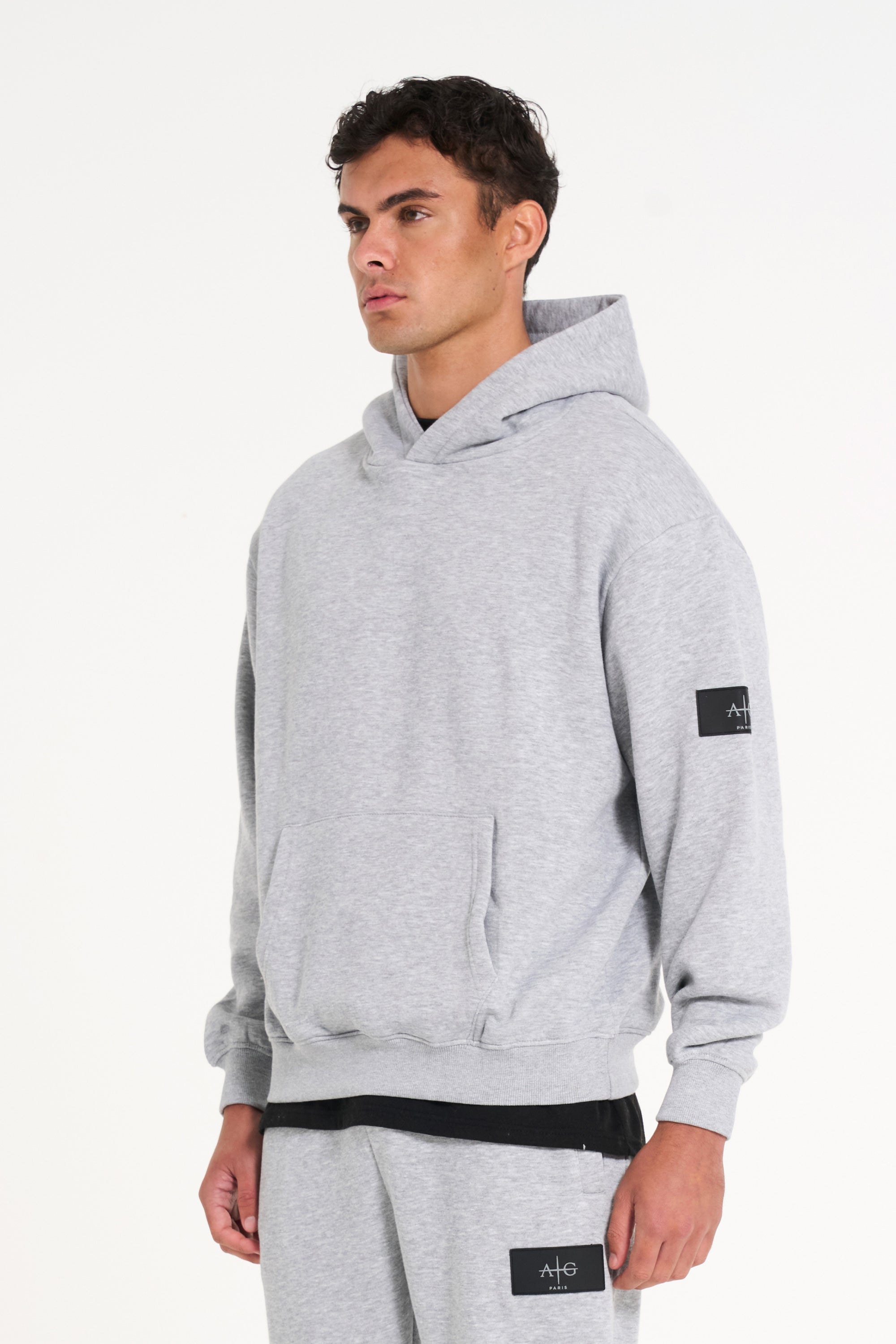 Top half of model wearing full tracksuit in grey facing to the side