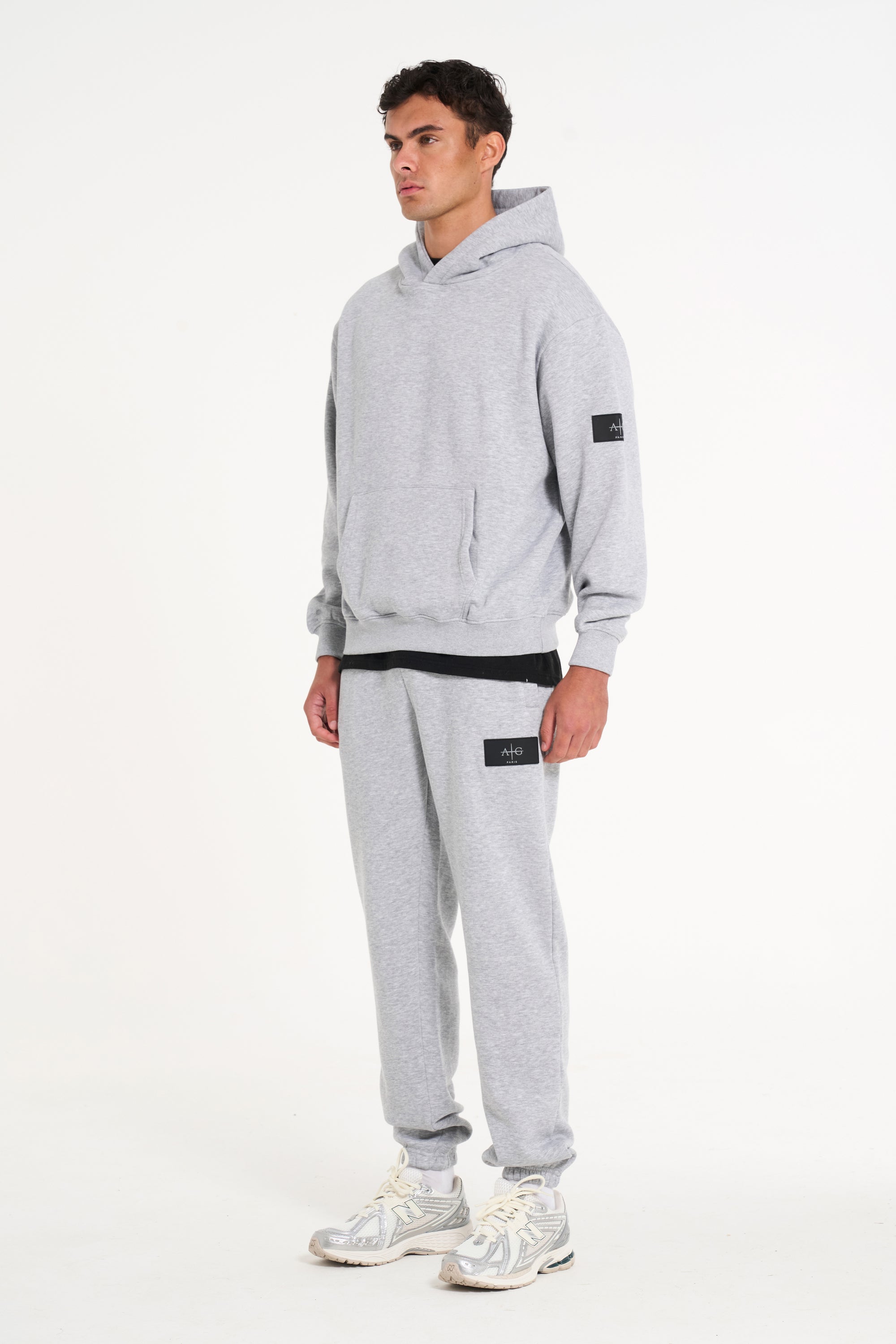 Model facing sidewards wearing grey full tracksuit with Avant Garde badge logo