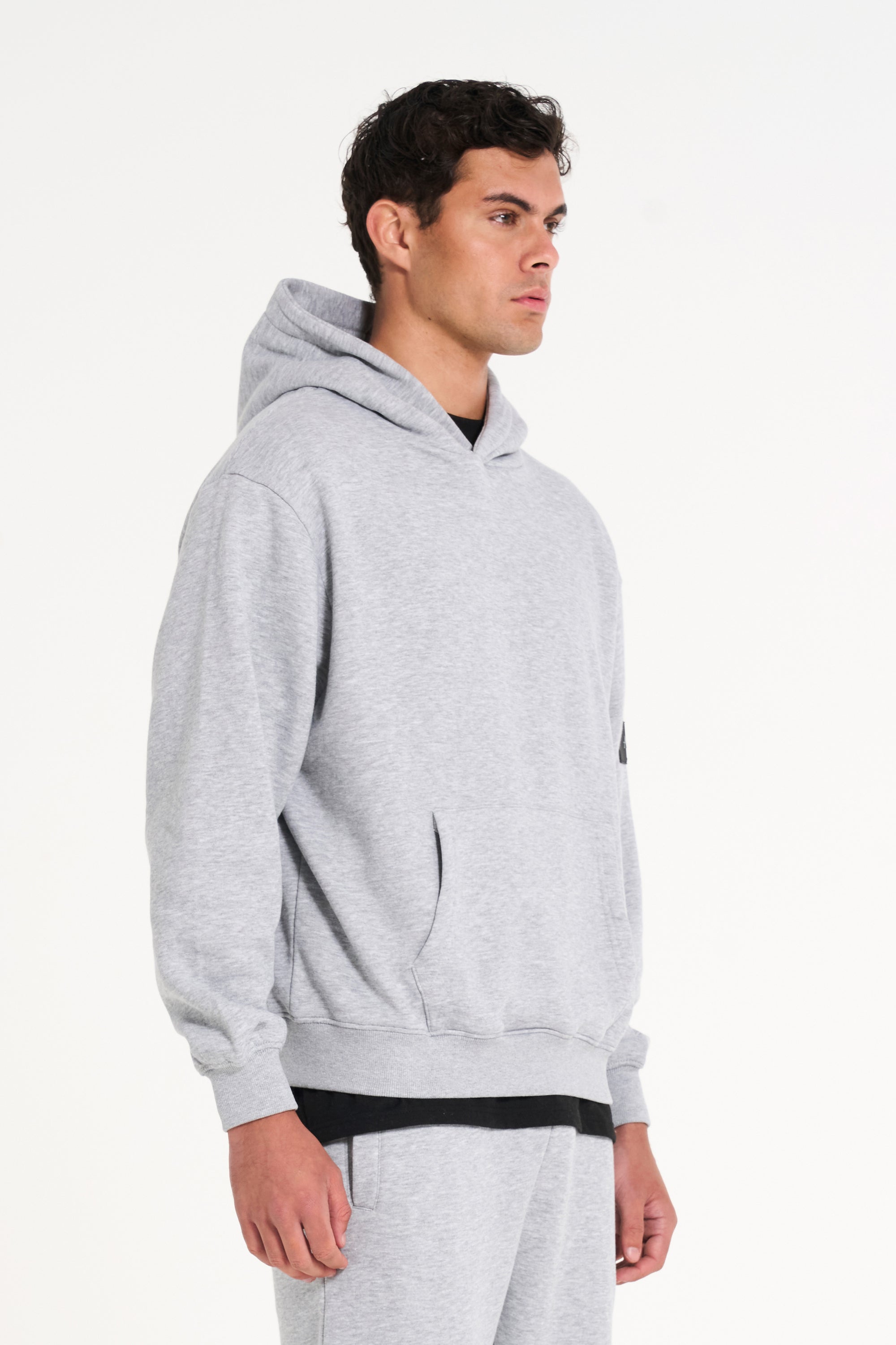 Top half of model facing to the right wearing a full men&#39;s tracksuit in grey