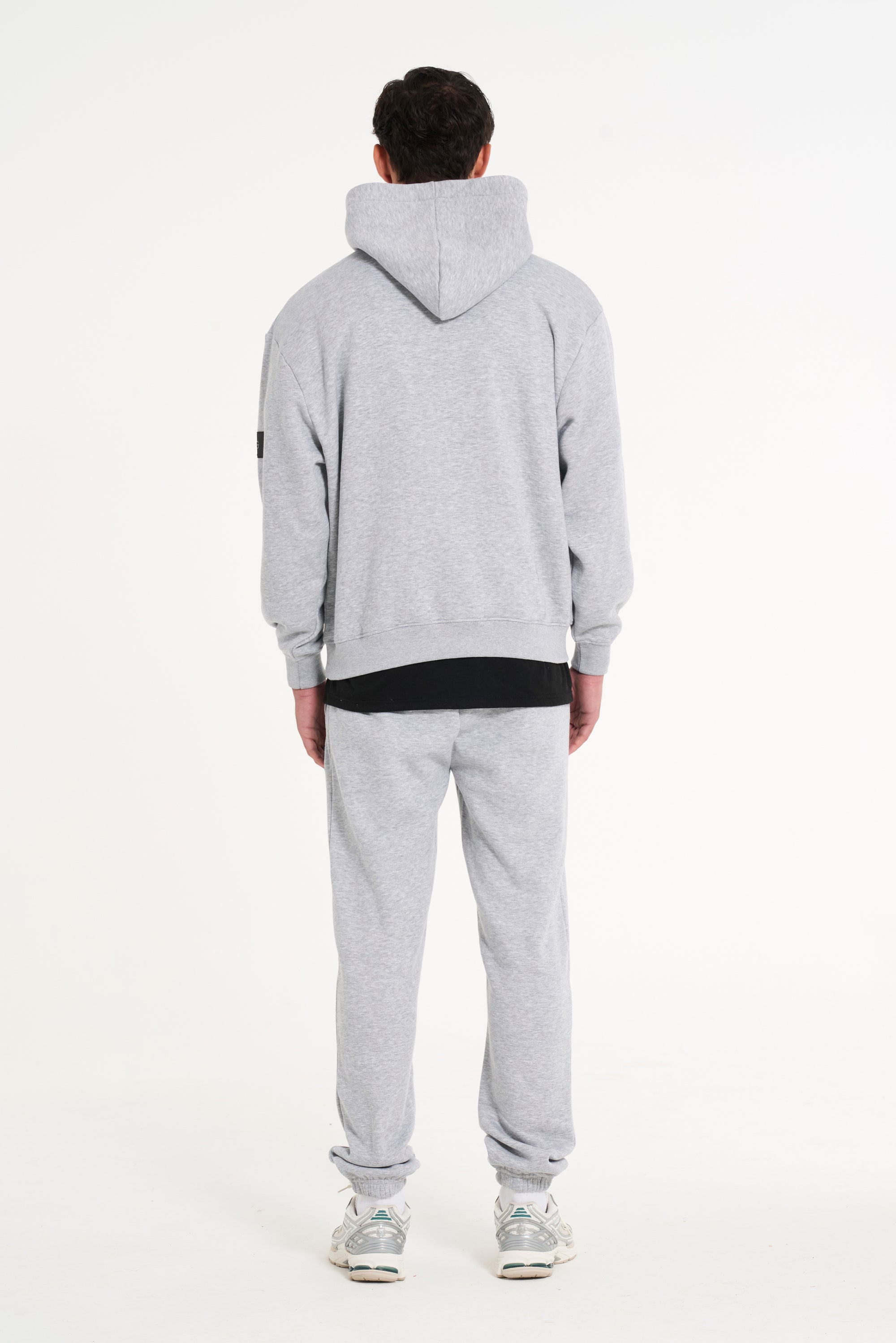 Model wearing full tracksuit in grey facing away from the camera