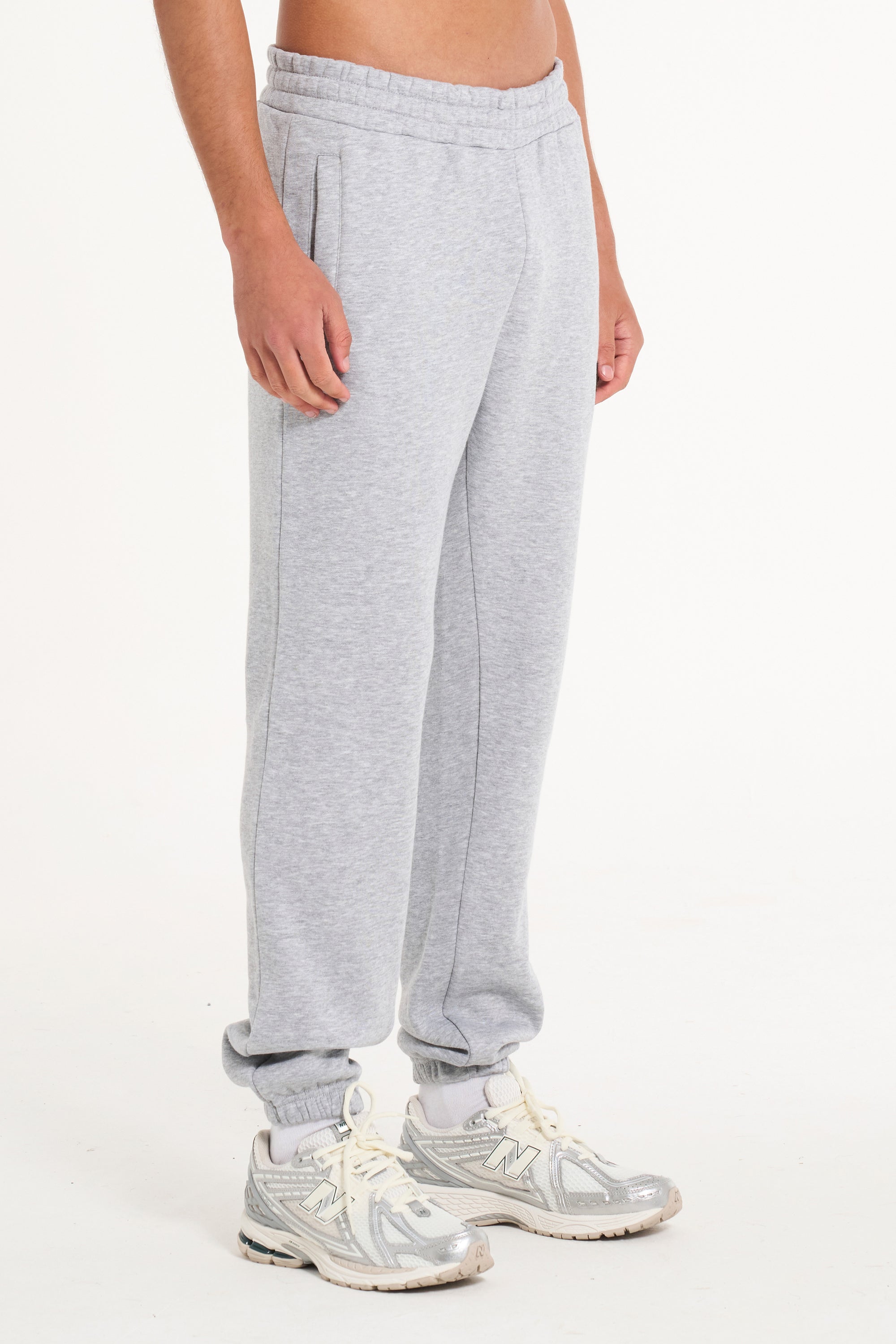 Model facing to the right showing bottom half of men&#39;s grey tracksuit