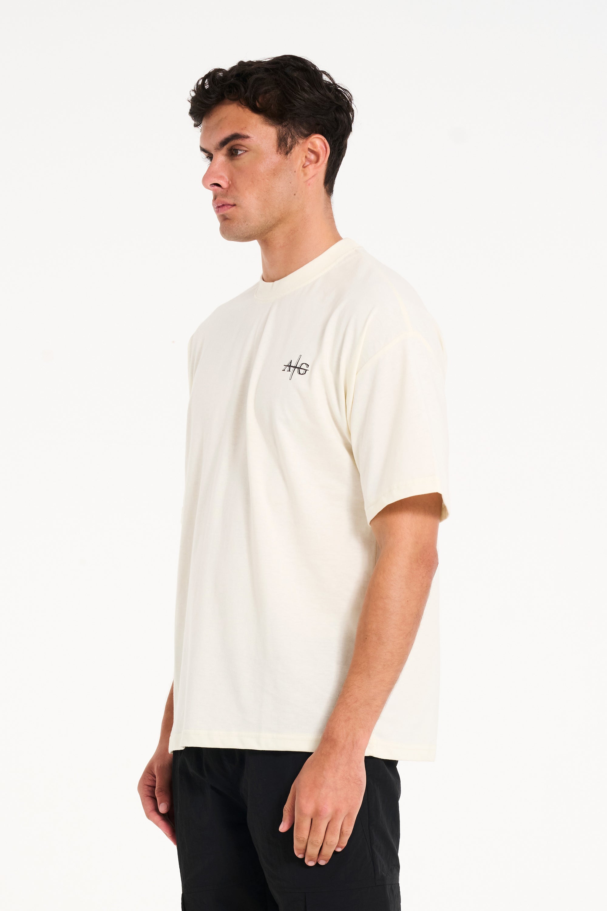 Man facing to the side wearing crew neck T-shirt in ecru