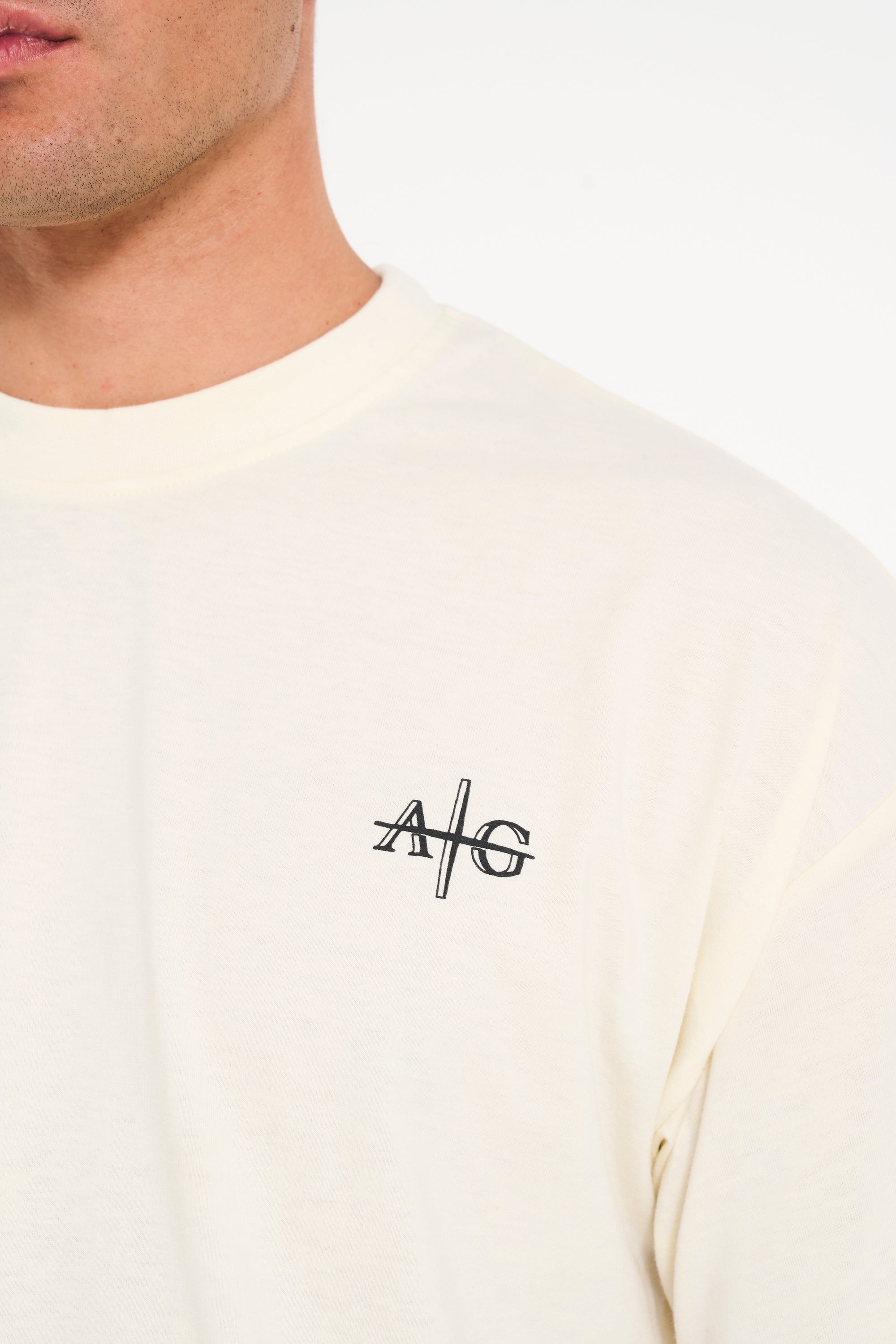 Close up shot of crew neck T-shirt in ecru with Avant Garde logo