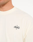 Close up shot of crew neck T-shirt in ecru with Avant Garde logo