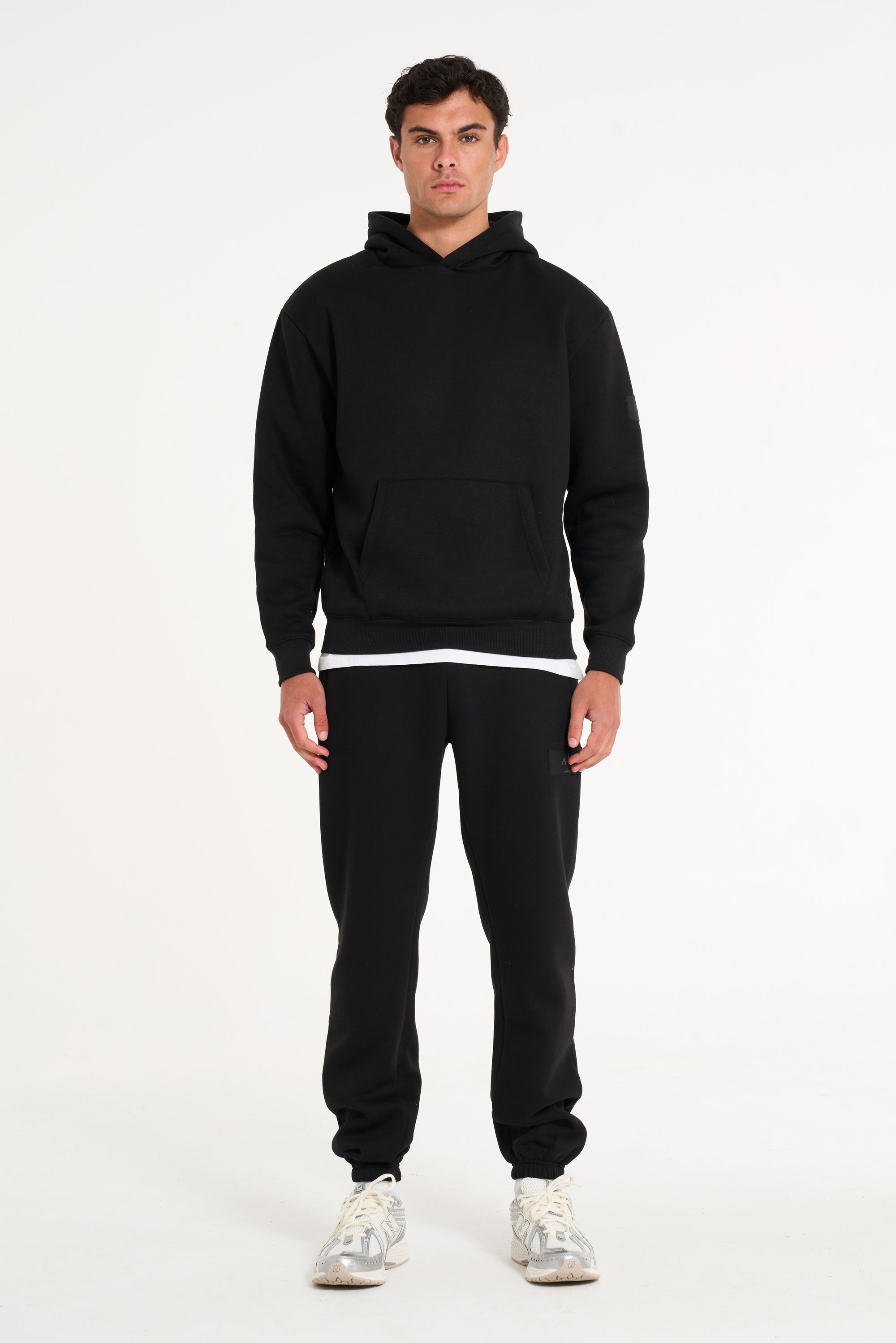 Frontshot of model wearing full tracksuit in black