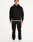 Frontshot of model wearing full tracksuit in black