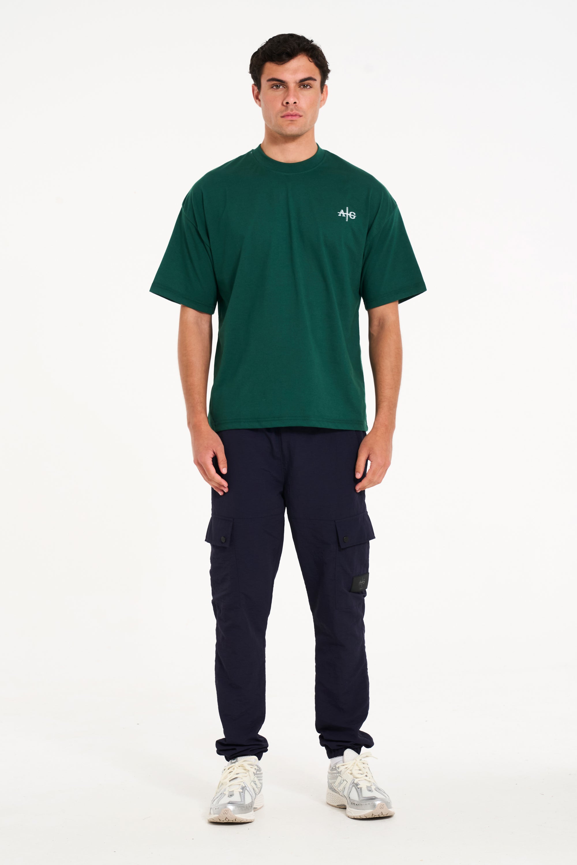 Model wearing green crew neck T-shirt with navy cargo pants