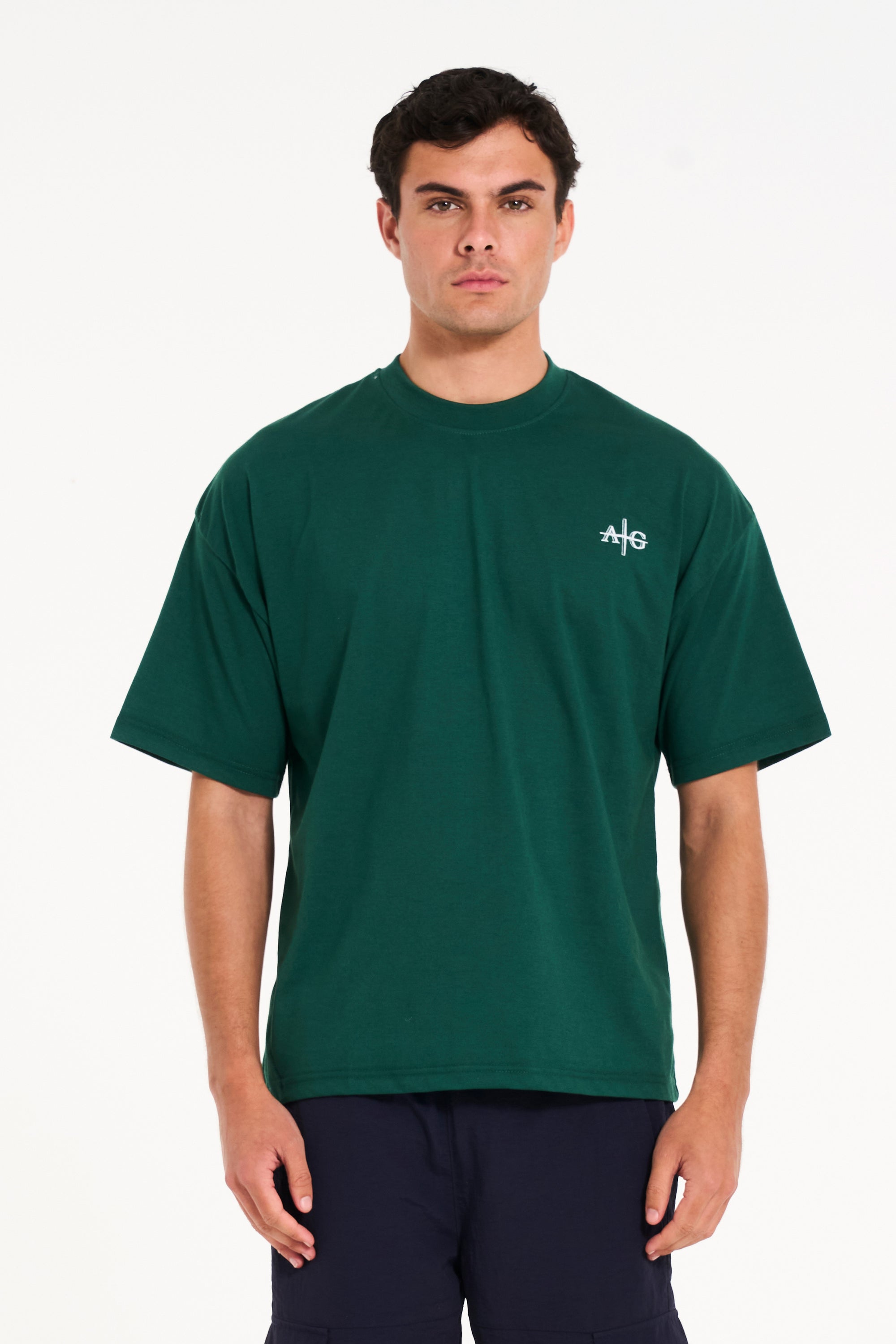 Front shot of model wearing green crew neck T-shirt with Avant Garde logo 