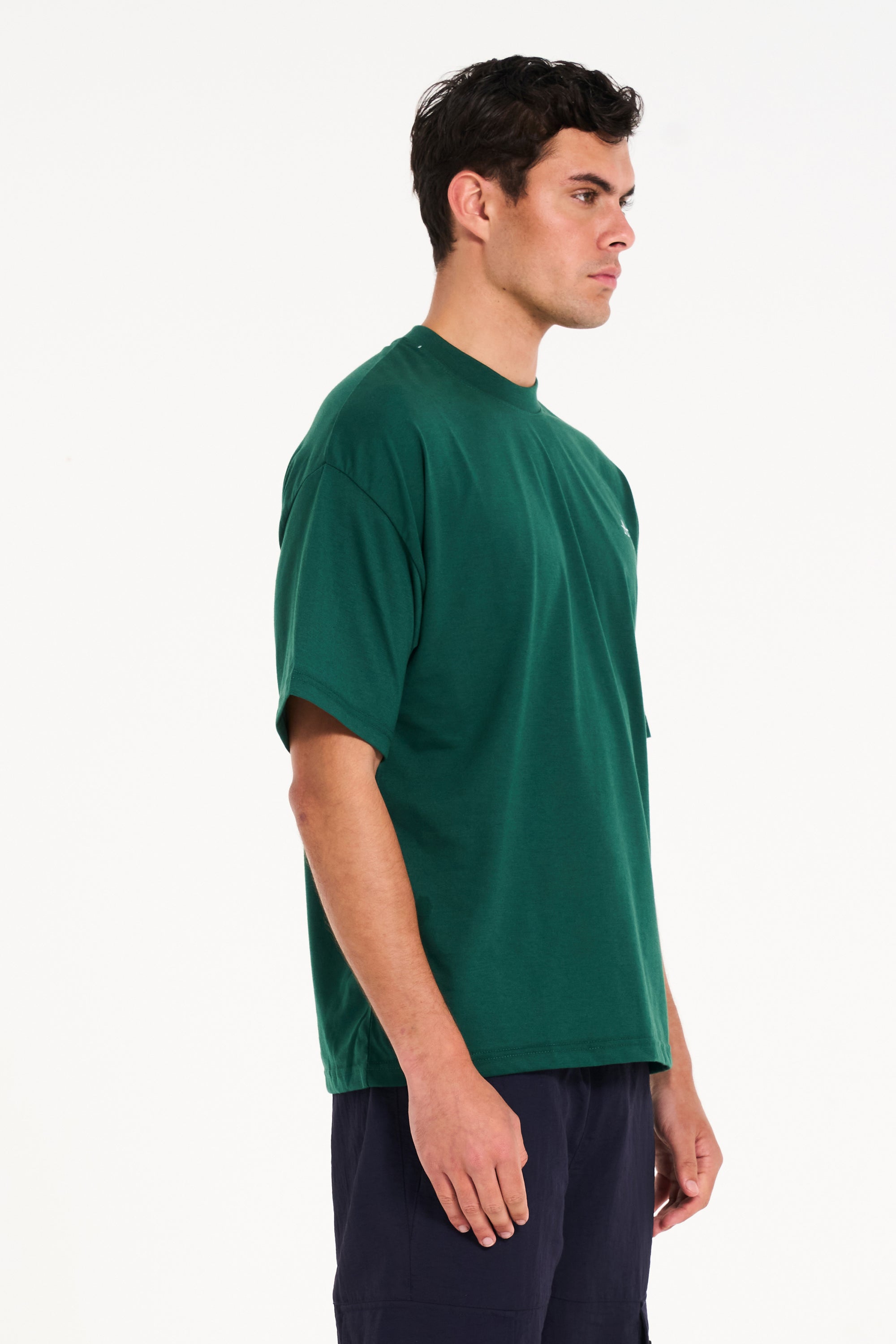 Model facing off to the right wearing green crew neck T-shirt