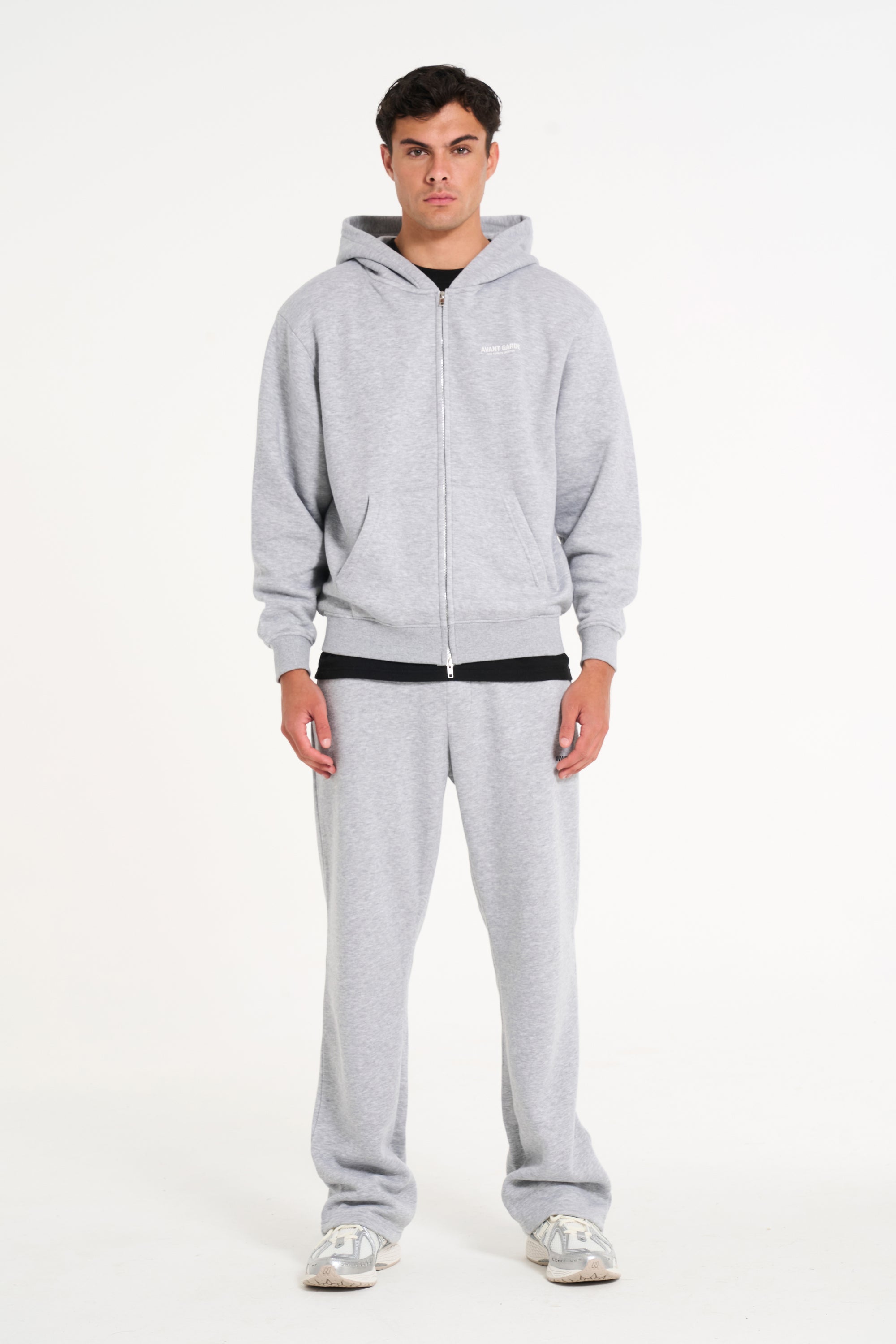 Model wearing full grey tracksuit with zip up hoodie and tracksuit bottoms